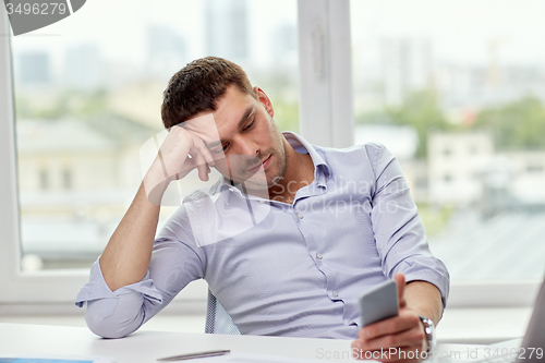 Image of  businessman with smartphone  at office 