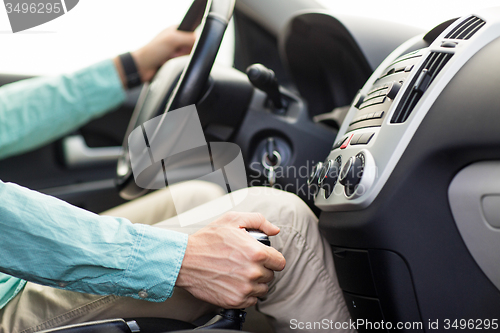 Image of close up of young man driving car