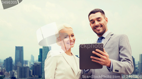 Image of smiling businessmen with tablet pc in city