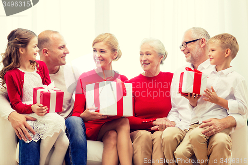 Image of smiling family with gifts at home