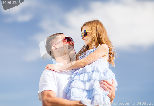 Image of happy father and child in sunglasses over blue sky