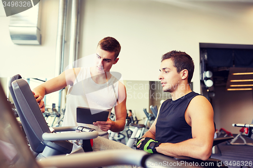 Image of men exercising on gym machine