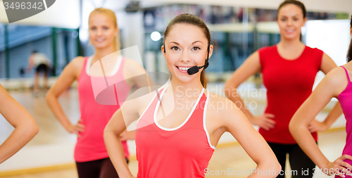 Image of group of smiling people exercising in the gym