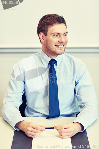 Image of smiling businessman sitting in office