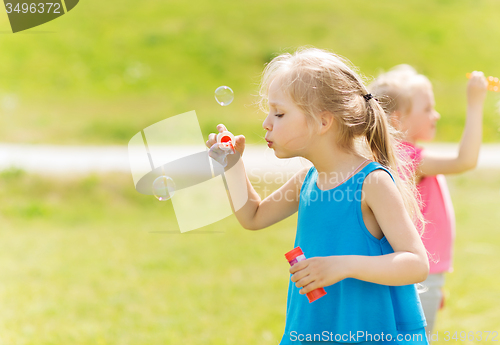 Image of group of kids blowing soap bubbles outdoors
