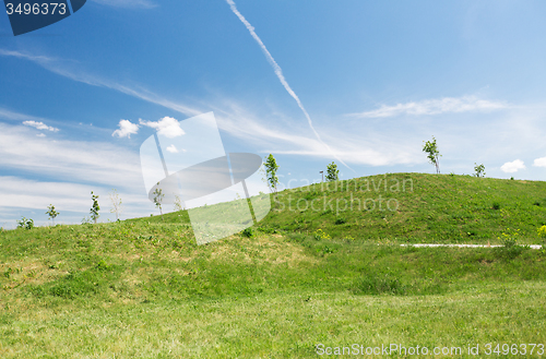 Image of summer green field and hills over blue sky 