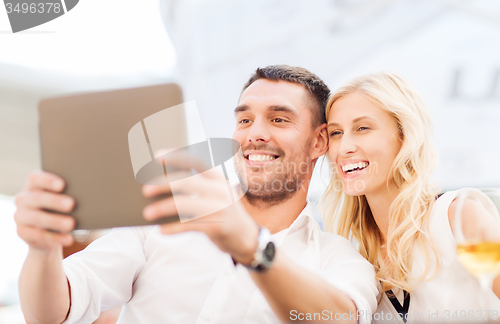 Image of happy couple with tablet pc at restaurant lounge