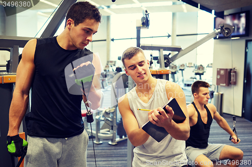 Image of men exercising on gym machine