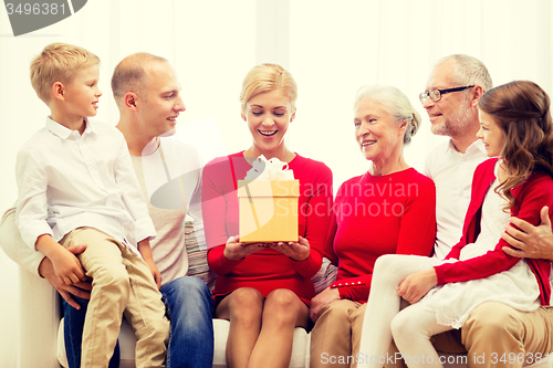 Image of smiling family with gift at home