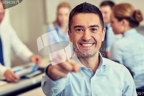 Image of group of smiling businesspeople meeting in office