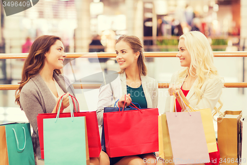 Image of happy young women with shopping bags in mall