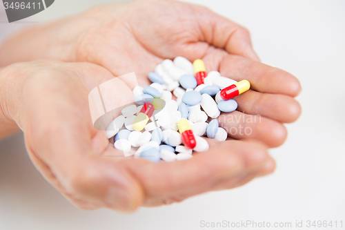 Image of close up of senior woman hands with pills