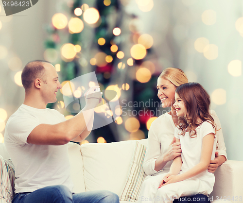Image of happy family with camera at home