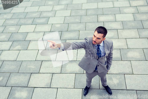 Image of young smiling businessman outdoors from top