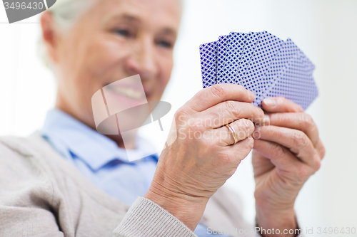 Image of close up of happy senior woman playing cards