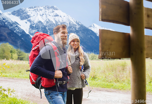 Image of smiling couple with backpacks hiking