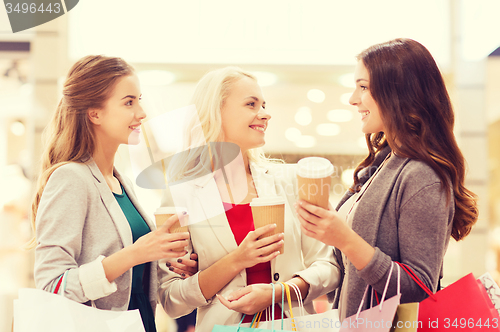 Image of young women with shopping bags and coffee in mall