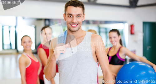 Image of smiling man standing in front of the group in gym