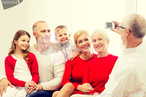 Image of smiling family with camera at home
