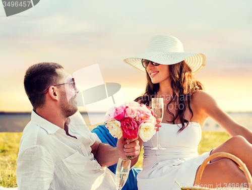 Image of smiling couple drinking champagne on picnic