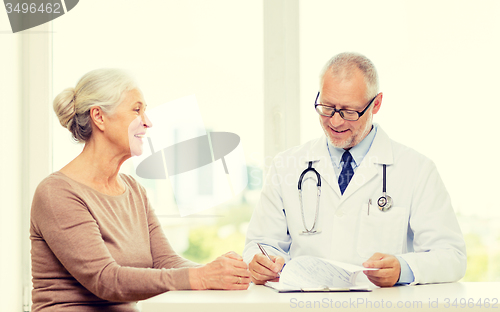 Image of smiling senior woman and doctor meeting