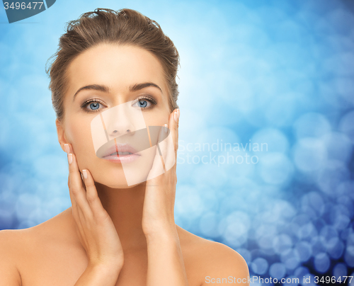 Image of beautiful young woman touching her face and neck