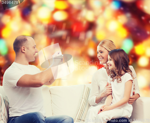 Image of happy family with camera at home