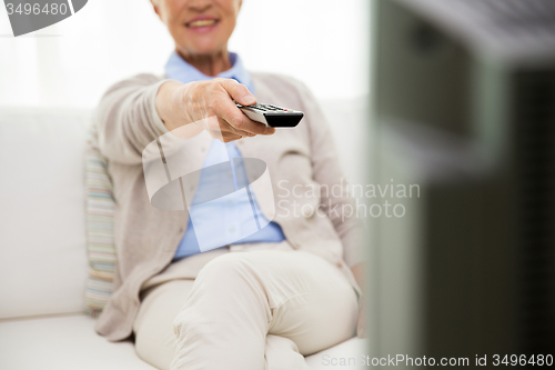 Image of close up of happy senior woman watching tv at home