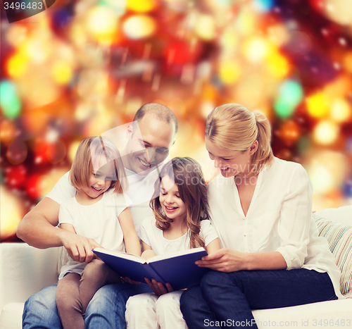 Image of happy family with book at home