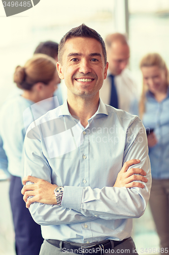 Image of group of smiling businesspeople meeting in office