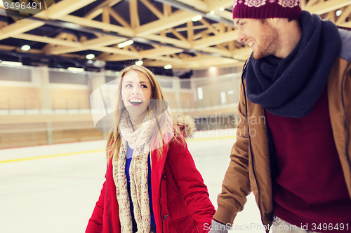 Image of happy couple holding hands on skating rink