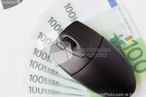 Image of close up of computer mouse and euro money