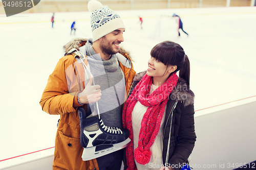 Image of happy couple with ice-skates on skating rink