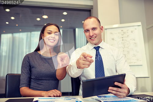 Image of smiling businesspeople with tablet pc in office