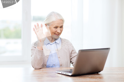 Image of senior woman with laptop having video chat at home