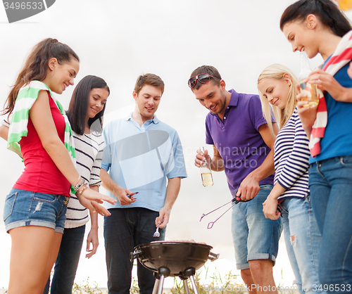 Image of group of friends having picnic on beach