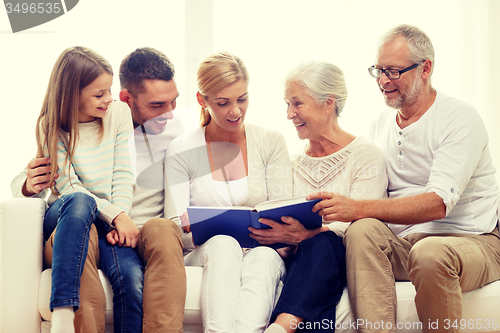 Image of happy family with book or photo album at home