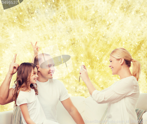 Image of happy family with camera at home
