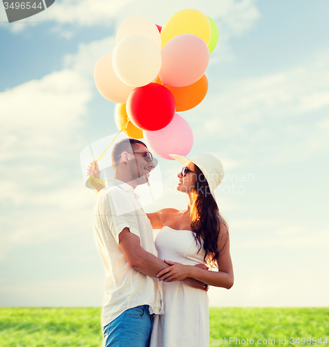 Image of smiling couple with air balloons outdoors