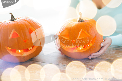 Image of close up of woman with pumpkins at home