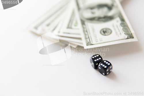 Image of close up of black dice and dollar cash money