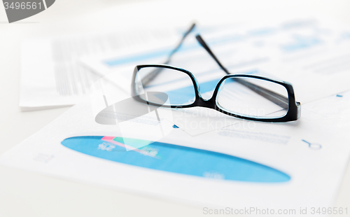 Image of close up of eyeglasses and files on office table