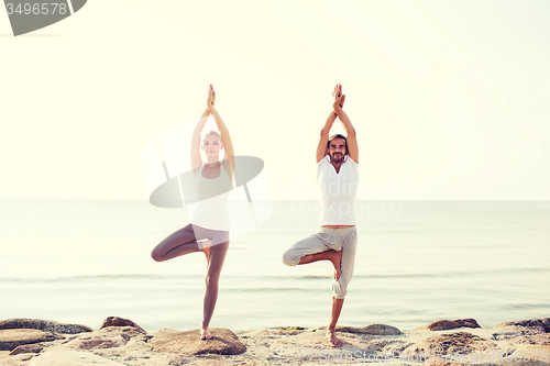Image of couple making yoga exercises outdoors