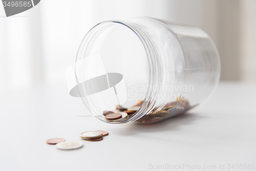 Image of close up of euro coins in glass jar on table