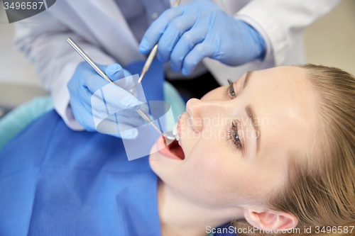 Image of close up of dentist checking female patient teeth