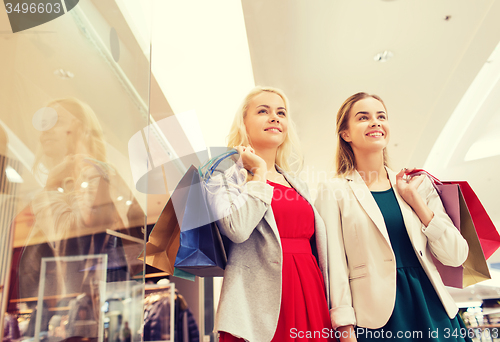 Image of happy young women with shopping bags in mall