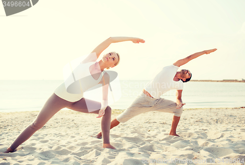 Image of couple making yoga exercises outdoors