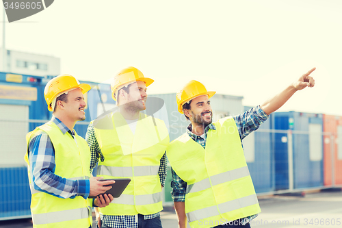 Image of smiling builders in hardhats with tablet pc