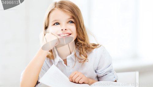 Image of little student girl studying at school