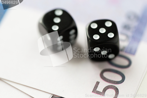 Image of close up of black dice and euro cash money